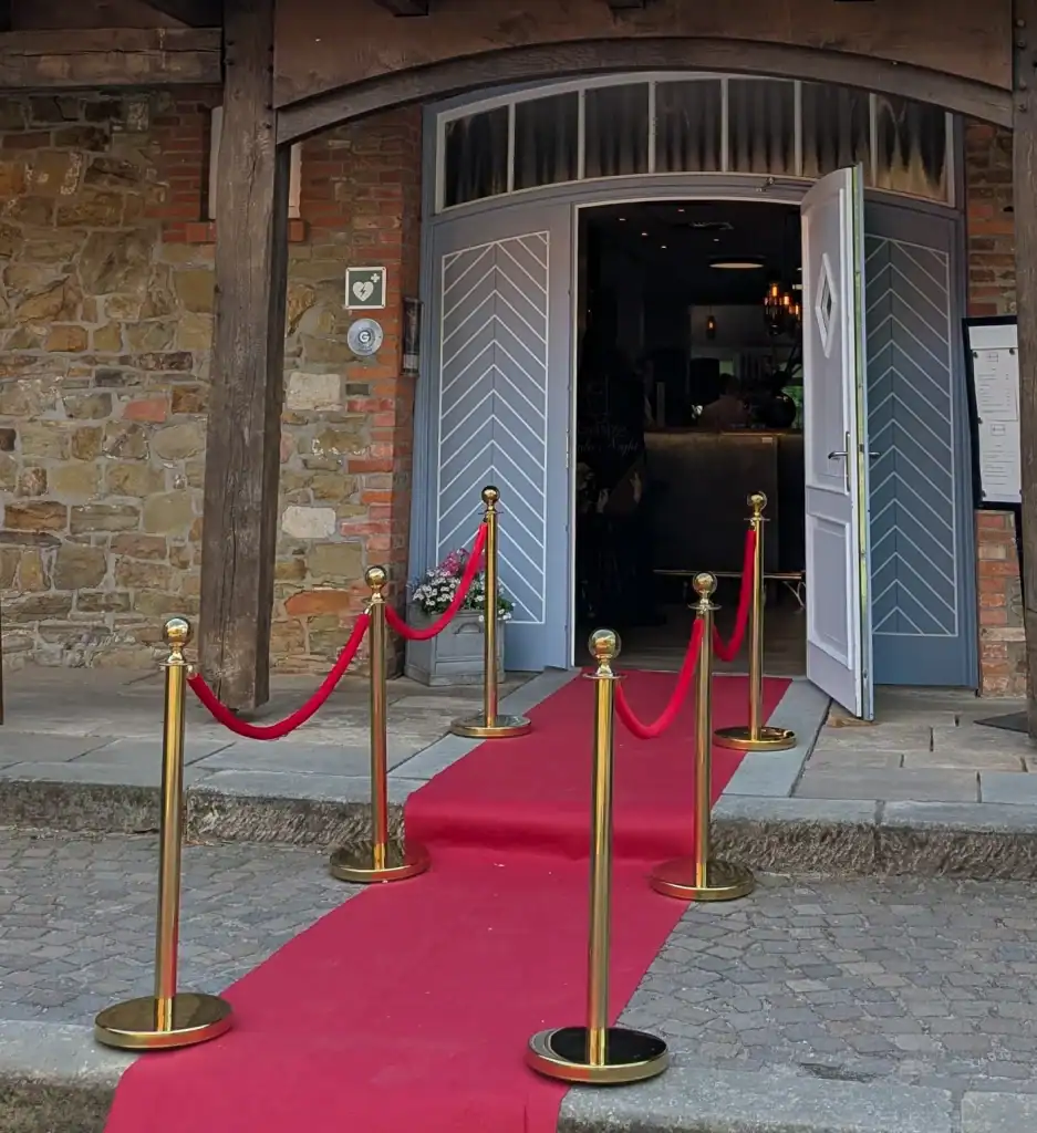 Roter Teppich mit goldenen Absperrpfosten für stilvollen Event-Empfang