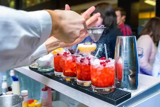 Barkeeper mixt Cocktails an mobiler Bar auf stilvollem Casino Event