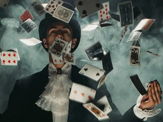 Close-up Magier verzaubert Gäste mit Kartentricks bei stilvollem Casino-Event