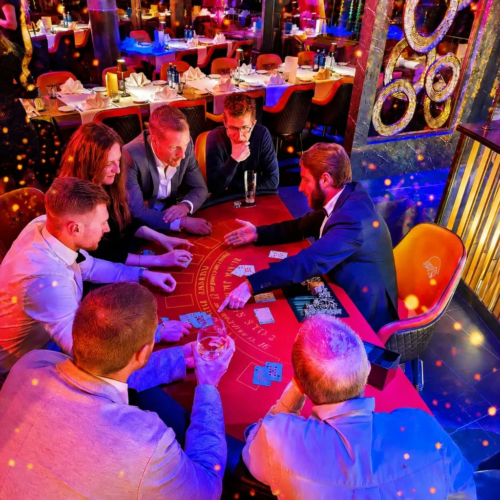 Gäste feiern ausgelassen auf einer stilvollen Casino Night mit Konfetti und festlicher Abendgarderobe
