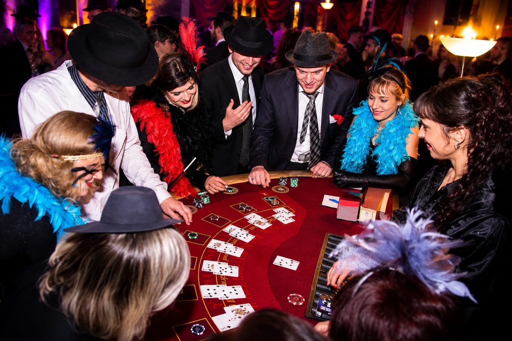 Gäste in 20er-Jahre-Kostümen spielen Blackjack bei einer glamourösen Casino Motto Party